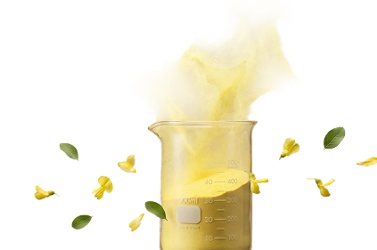 A glass beaker filled with yellow powder, with yellow powder particles and small green leaves suspended in the air above and around it, against a white background.